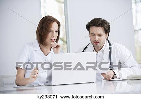 Doctors working on a laptop View Large Photo Image Stock Image - Doctors working on a laptop. Fotosearch