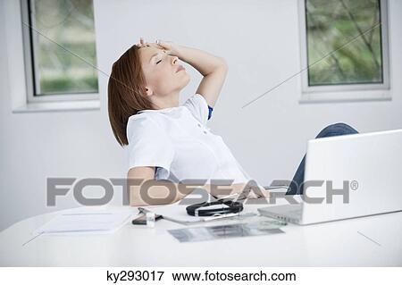 Female doctor resting in an office View Large Photo Image Stock Photo - Female doctor resting in an office. Fotosearch