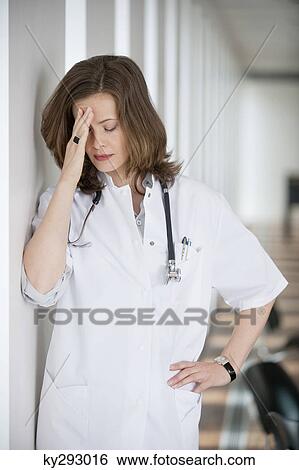 Female doctor suffering from a headache View Large Photo Image Stock Photograph - Female doctor suffering from a headache. Fotosearch