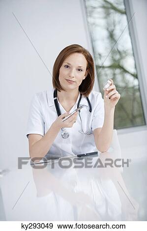 Female doctor working in an office View Large Photo Image Stock Photo - Female doctor working in an office. Fotosearch