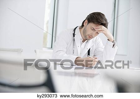 Male doctor sitting in his office and looking upset View Large Photo Image Stock Image - Male doctor sitting in his office and looking upset. Fotosearch