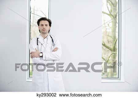 Portrait of a doctor standing with his arms crossed View Large Photo Image Stock Image - Portrait of a doctor standing with his arms crossed. Fotosearch