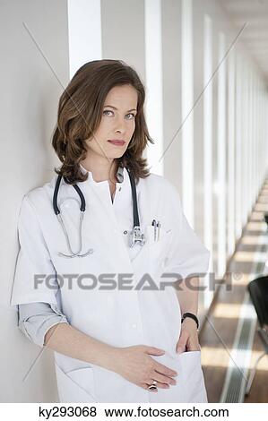 Portrait of a female doctor standing in the corridor View Large Photo Image Stock Photo - Portrait of a female doctor standing in the corridor. Fotosearch