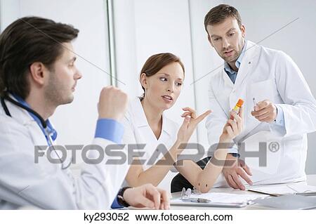 Three doctors examining medicine View Large Photo Image Stock Image - Three doctors examining medicine. Fotosearch