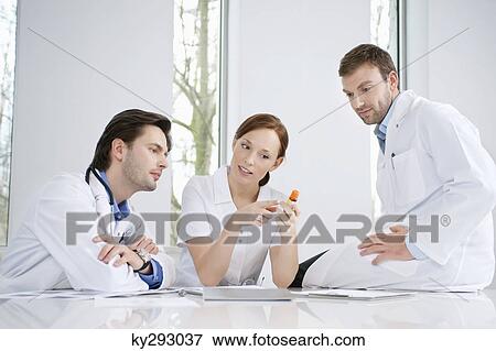 Stock Photo - Three doctors examining medicine. Fotosearch
