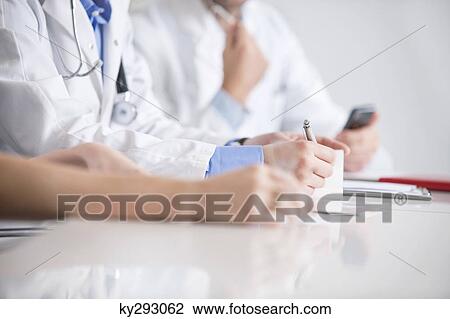 Three doctors sitting in an office View Large Photo Image Stock Image - Three doctors sitting in an office. Fotosearch