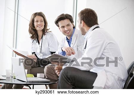 Three doctors talking to each other View Large Photo Image Stock Image - Three doctors talking to each other. Fotosearch