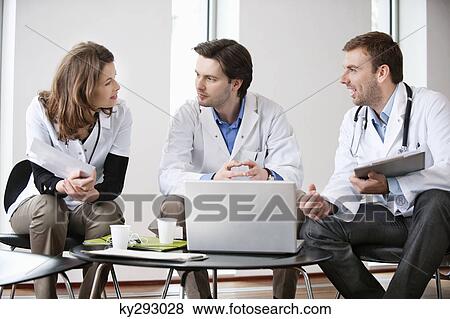 Three doctors talking to each other View Large Photo Image Stock Photo - Three doctors talking to each other. Fotosearch