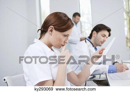 Stock Photo - Three doctors working in an office. Fotosearch