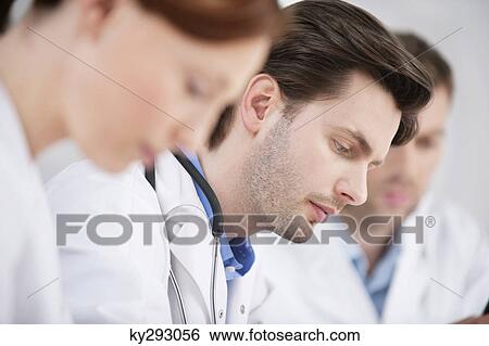 Three doctors working in an office View Large Photo Image Stock Photograph - Three doctors working in an office. Fotosearch