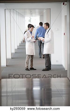 Stock Photo - Two male doctors discussing a medical report. Fotosearch