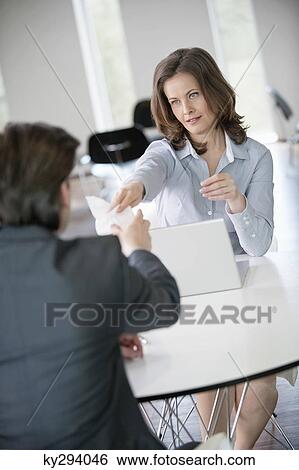 Businesswoman giving a bill to an advisor View Large Photo Image Stock Photograph - Businesswoman giving a bill to an advisor. Fotosearch
