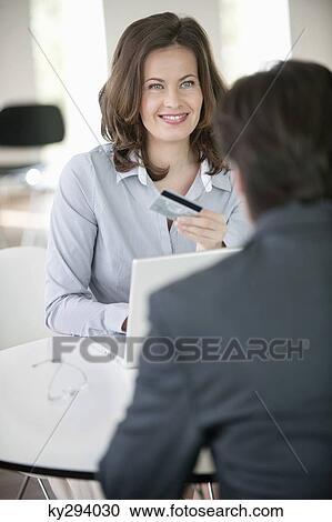 Businesswoman showing a credit card to a businessman View Large Photo Image Stock Image - Businesswoman showing a credit card to a businessman. Fotosearch