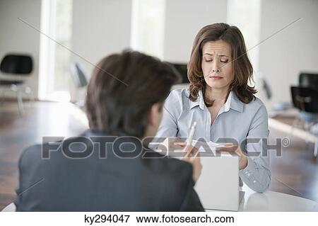 Stock Photo - Businesswoman upset while looking at a bill. Fotosearch