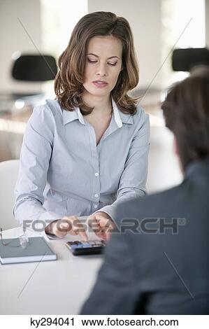 Businesswoman using a calculator View Large Photo Image Stock Image - Businesswoman using a calculator. Fotosearch