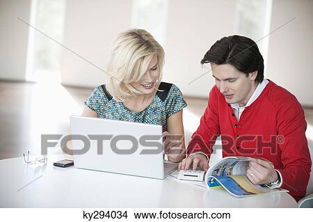 Couple using a laptop and a calculator View Large Photo Image Picture - Couple using a laptop and a calculator. Fotosearch
