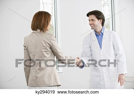 Doctor shaking hand with a woman View Large Photo Image Stock Photo - Doctor shaking hand with a woman. Fotosearch