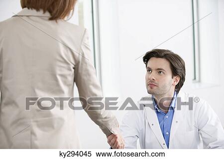 Doctor shaking hand with a woman View Large Photo Image Stock Photography - Doctor shaking hand with a woman. Fotosearch