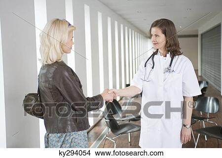 Female doctor shaking hand with a woman View Large Photo Image Picture - Female doctor shaking hand with a woman. Fotosearch