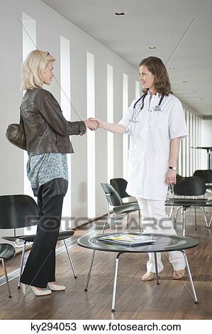 Female doctor shaking hand with a woman View Large Photo Image Stock Image - Female doctor shaking hand with a woman. Fotosearch