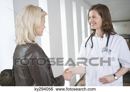 Female doctor shaking hand with a woman View Large Photo Image Stock Photograph - Female doctor shaking hand with a woman. Fotosearch