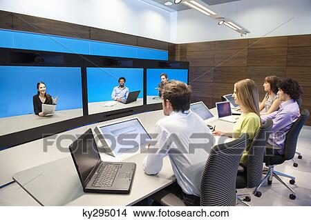 Picture - Business executives working in a control room. Fotosearch