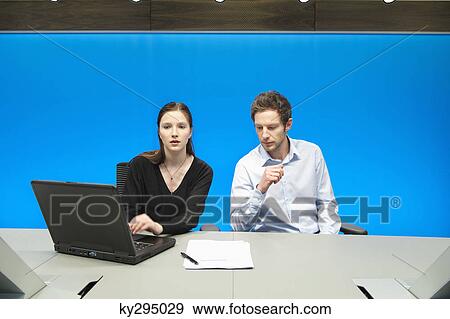 Business executives working on a laptop in a conference room View Large Photo Image Stock Photo - Business executives working on a laptop in a conference room. Fotosearch