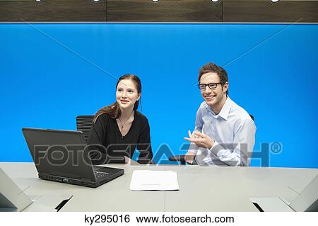 Stock Photograph - Business executives working on a laptop in a conference room. Fotosearch