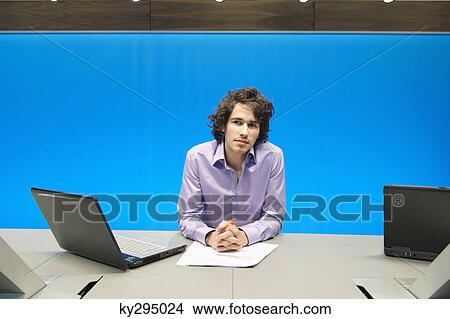 Businessman at a conference table with a laptop View Large Photo Image Picture - Businessman at a conference table with a laptop. Fotosearch