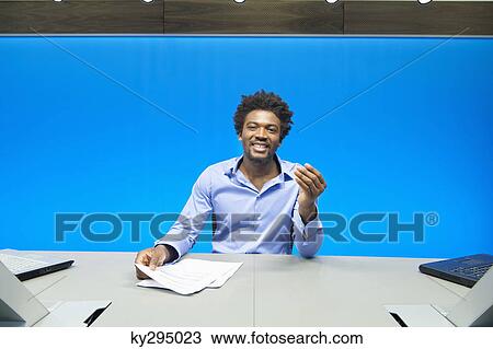Businessman doing paperwork and smiling in a conference room View Large Photo Image Stock Image - Businessman doing paperwork and smiling in a conference room. Fotosearch