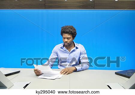 Businessman reading documents in a conference room View Large Photo Image Stock Image - Businessman reading documents in a conference room. Fotosearch