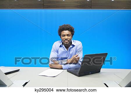 Businessman smiling with a laptop in a conference room View Large Photo Image Picture - Businessman smiling with a laptop in a conference room. Fotosearch
