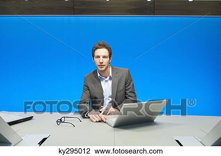 Businessman working on a laptop in a conference room View Large Photo Image Stock Image - Businessman working on a laptop in a conference room. Fotosearch