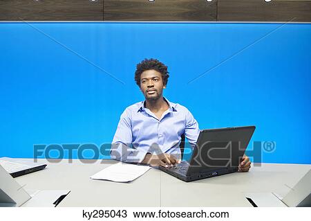 Businessman working on a laptop in a conference room View Large Photo Image Stock Image - Businessman working on a laptop in a conference room. Fotosearch