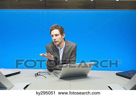 Businessman working on a laptop in a conference room View Large Photo Image Stock Image - Businessman working on a laptop in a conference room. Fotosearch
