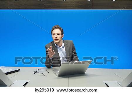 Stock Photo - Businessman working on a laptop in a conference room. Fotosearch