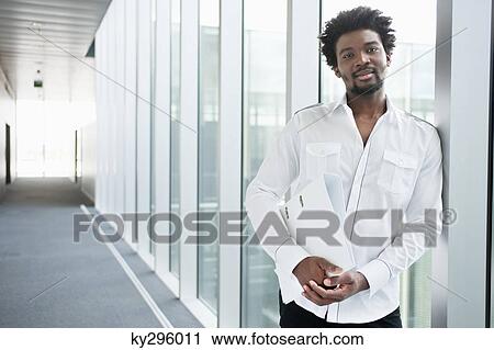 Businessman holding a folder and smiling View Large Photo Image Stock Image - Businessman holding a folder and smiling. Fotosearch