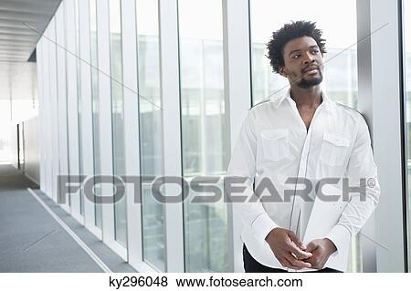 Stock Photo - Businessman holding a folder and thinking. Fotosearch