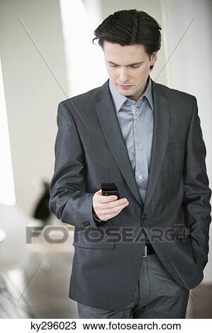 Businessman text messaging on a mobile phone View Large Photo Image Stock Image - Businessman text messaging on a mobile phone. Fotosearch