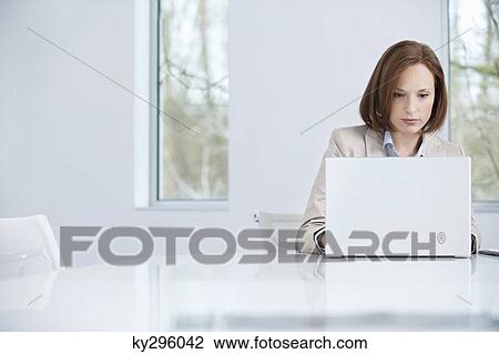 Businesswoman working on a laptop View Large Photo Image Stock Image - Businesswoman working on a laptop. Fotosearch