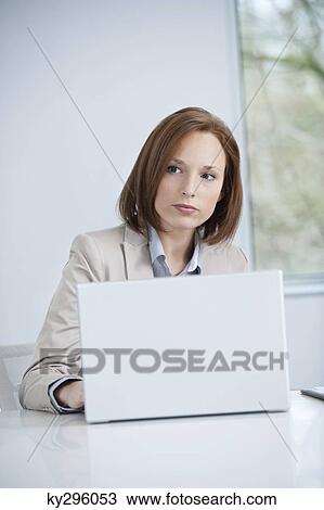 Businesswoman working on a laptop View Large Photo Image Stock Image - Businesswoman working on a laptop. Fotosearch
