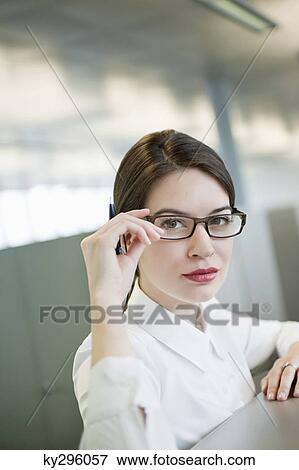 Stock Photo - Portrait of a businesswoman adjusting her eyeglasses. Fotosearch