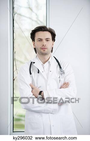 Portrait of a doctor standing with his arms crossed View Large Photo Image Stock Image - Portrait of a doctor standing with his arms crossed. Fotosearch