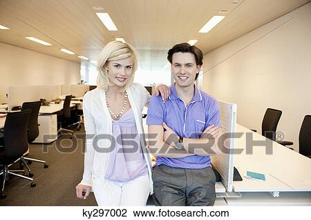 Business couple smiling in an office View Large Photo Image Stock Image - Business couple smiling in an office. Fotosearch