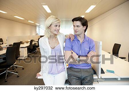 Business couple smiling in an office View Large Photo Image Stock Image - Business couple smiling in an office. Fotosearch