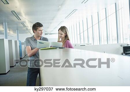 Stock Photo - Business executives doing paperwork in an office. Fotosearch