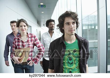 Business executives walking in an office View Large Photo Image Picture - Business executives walking in an office. Fotosearch