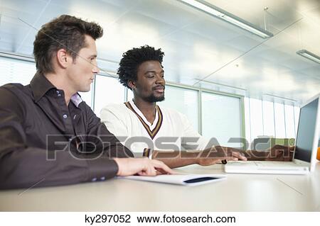 Business executives working on a laptop in an office View Large Photo Image Stock Image - Business executives working on a laptop in an office. Fotosearch
