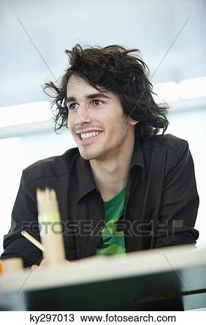 Stock Image - Businessman smiling in an office. Fotosearch