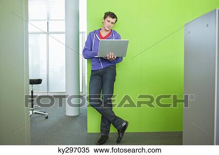 Businessman using a laptop in an office View Large Photo Image Stock Photography - Businessman using a laptop in an office. Fotosearch